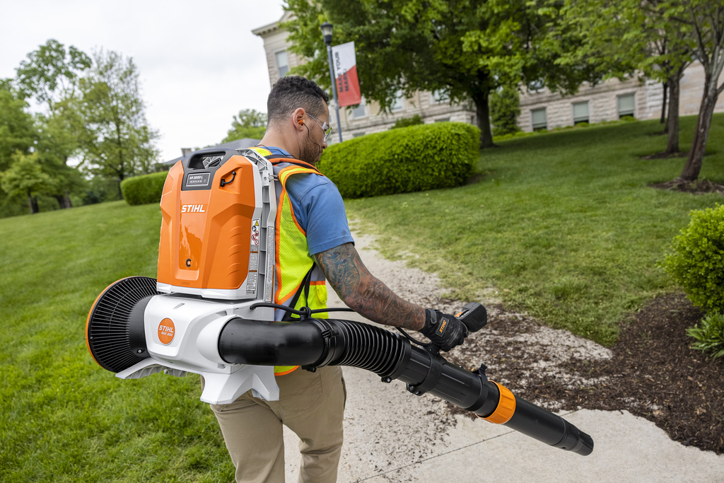 Landscaper clearing leaves with a STIHL backpack leaf blower